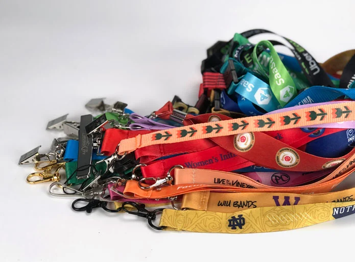 a big stack of lanyards showing a wide range of custom designs, sizes, attachments and print methods 